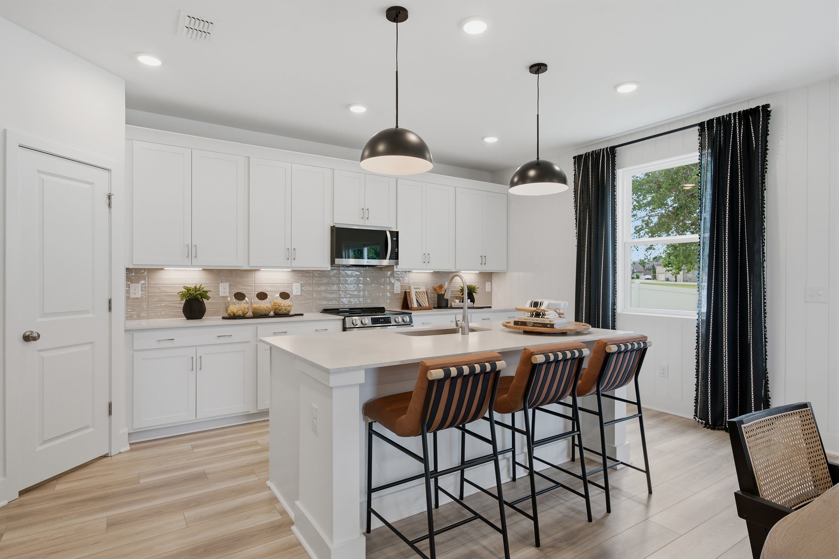 A kitchen with white cabinets.