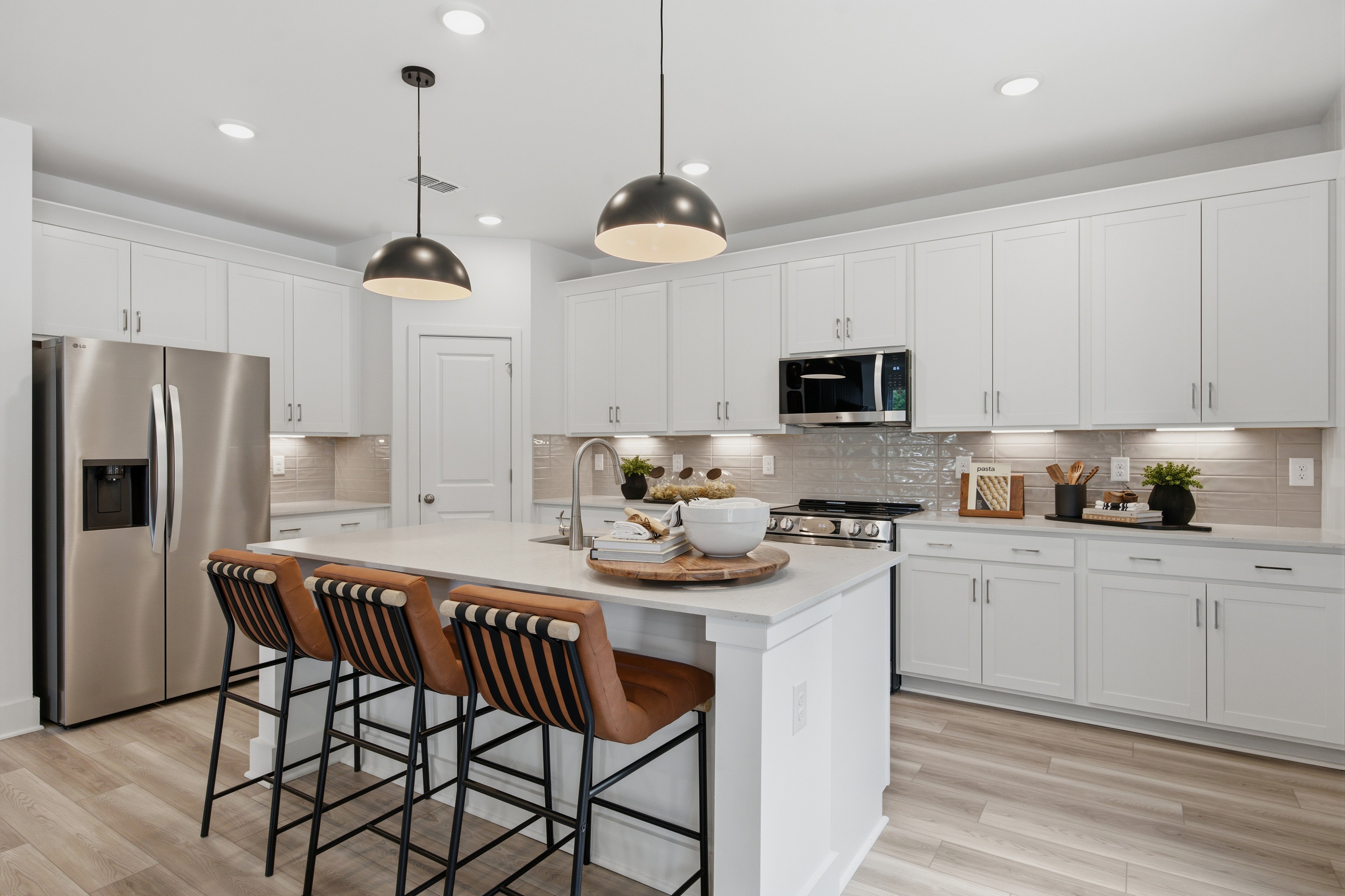 A kitchen with white cabinets.