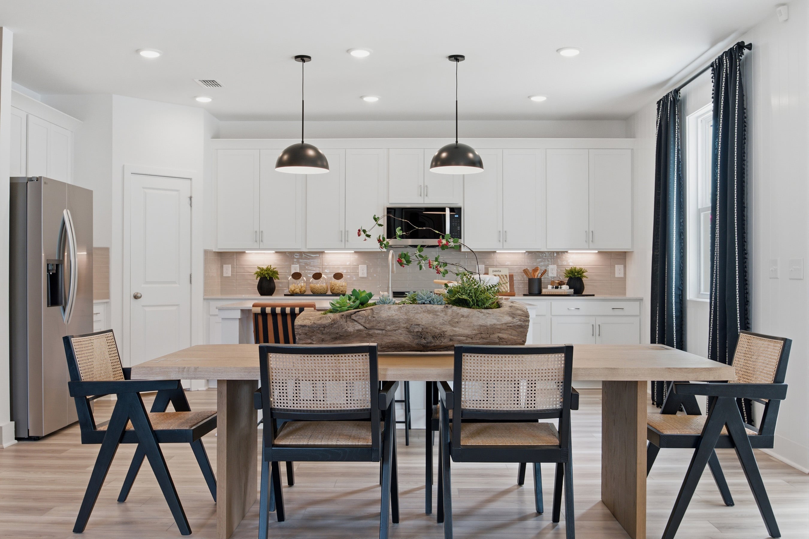 A kitchen with a dining table and chairs.