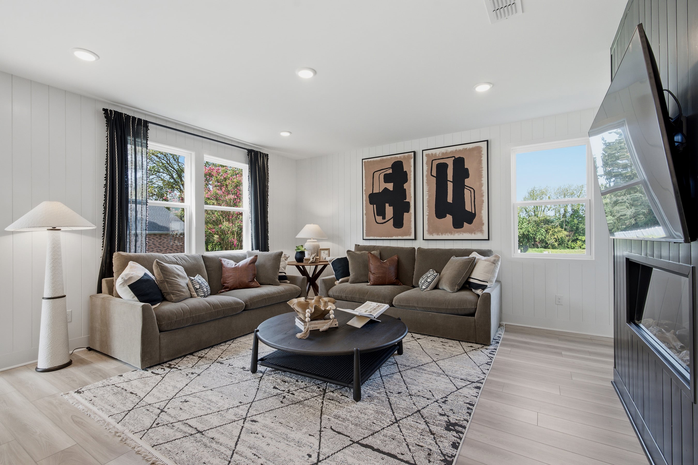 A living room with a large television and couches.
