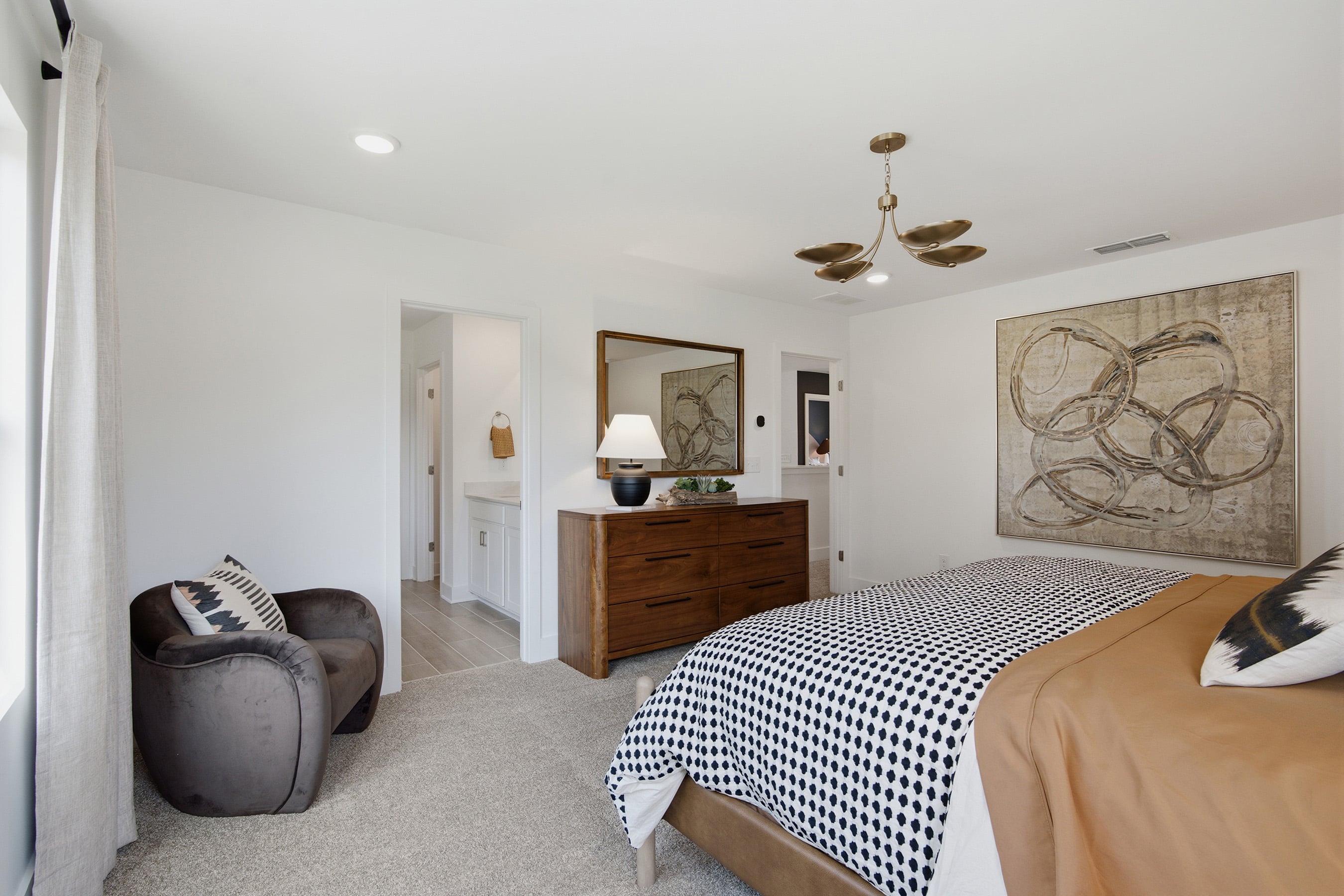 A bedroom with a bed and a chair.