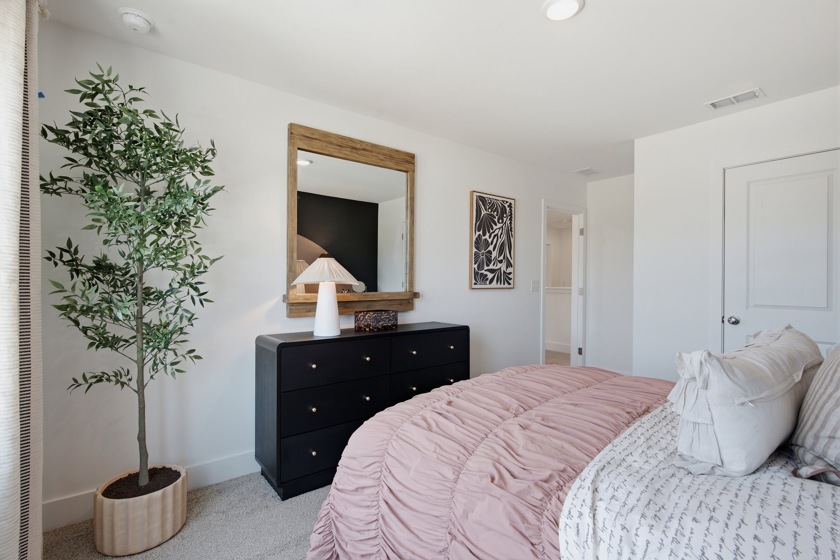A bedroom with a bed and a dresser.