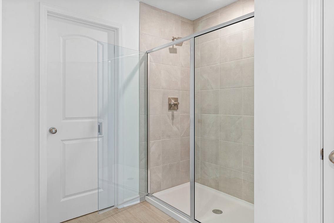 A bathroom with a shower unit and a bathtub.