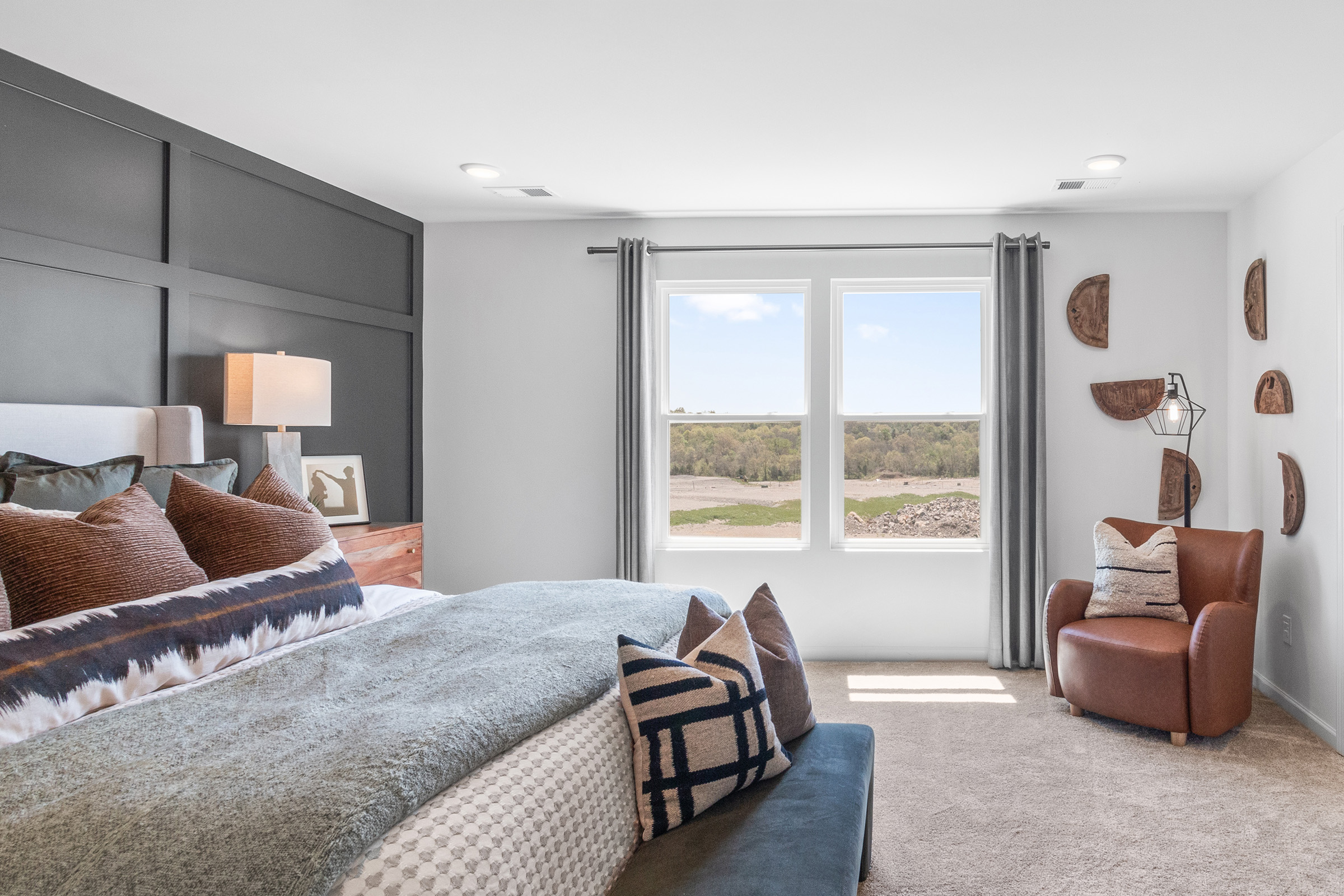 A bedroom with a large window.