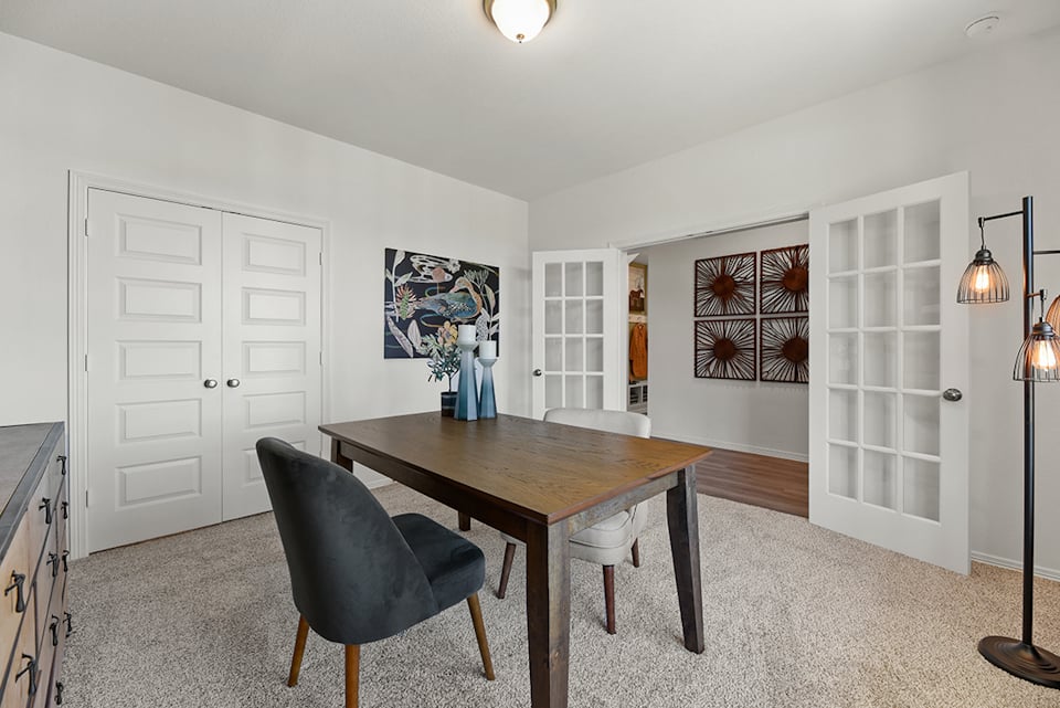 A dining room with a table and chairs.