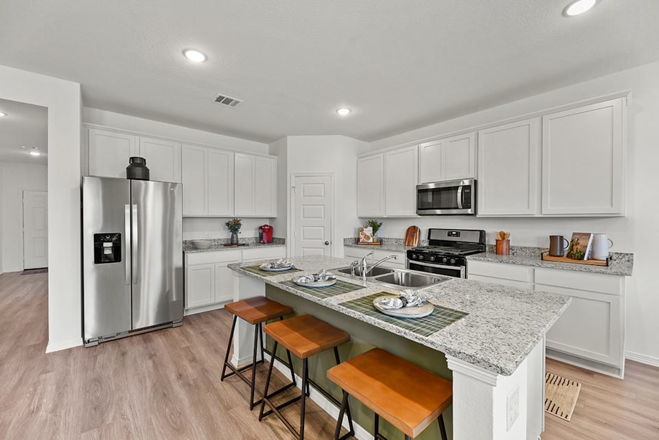 A kitchen with white cabinets.