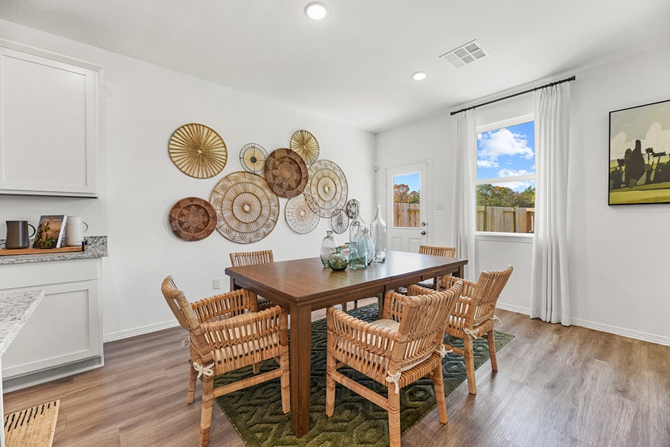 A dining room with a table and chairs.