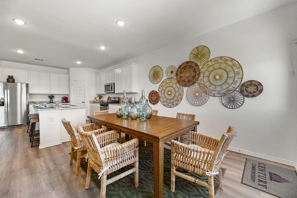 A kitchen with a table and chairs.