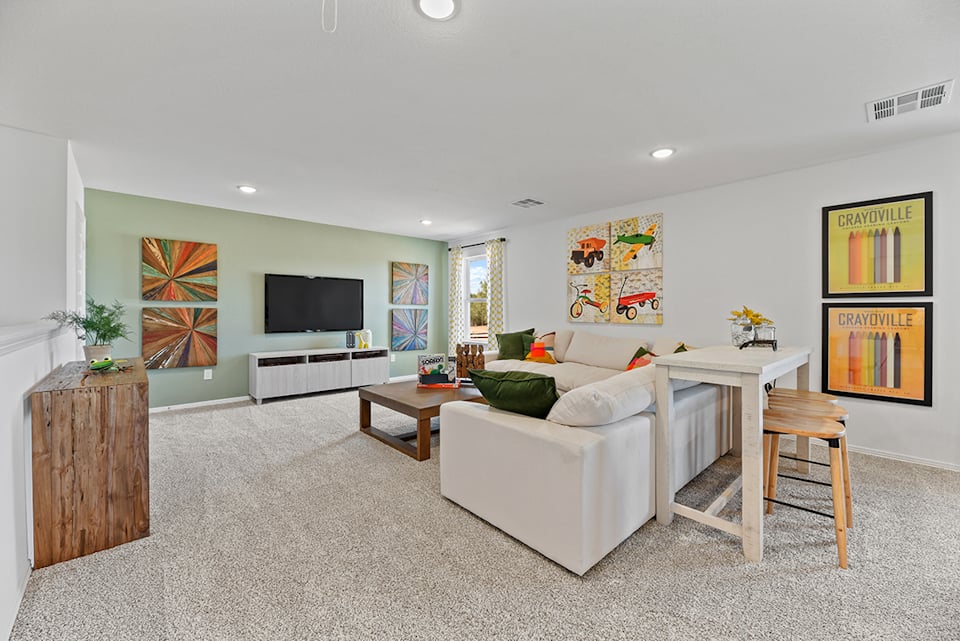 A living room with a white couch and a tv.