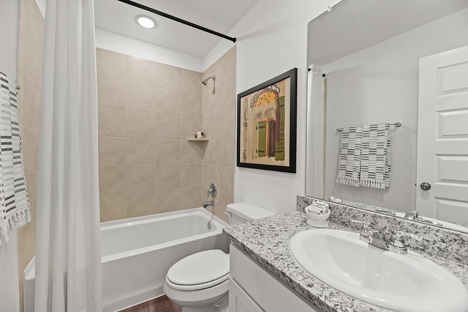 A bathroom with a tub sink and toilet.