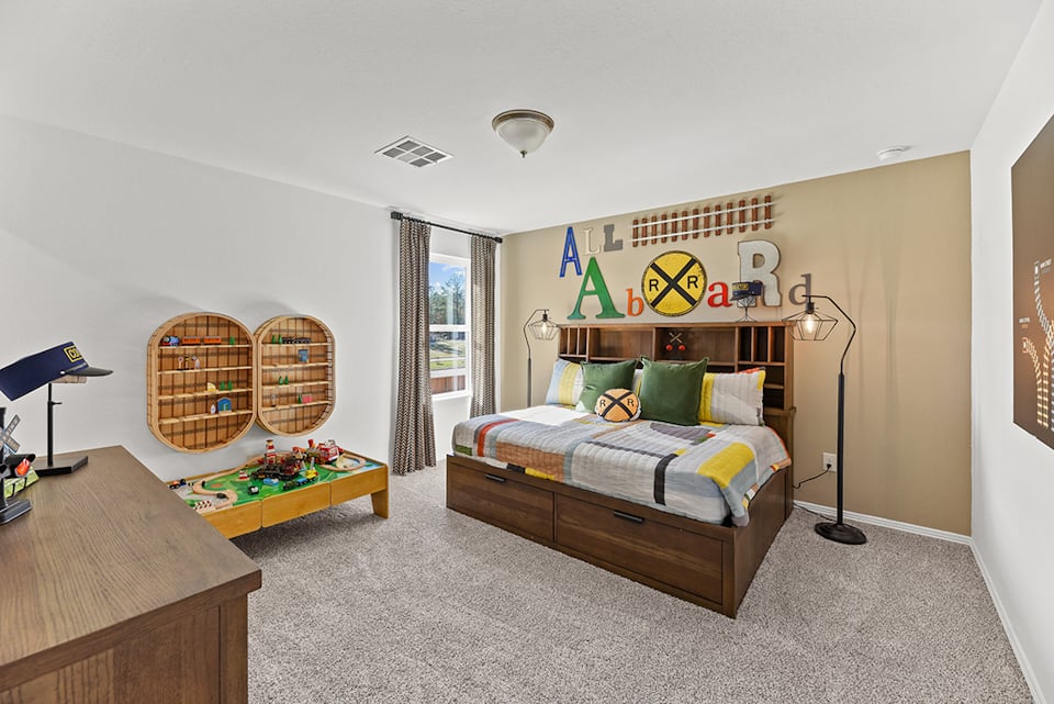 A bedroom with a bed and desk.