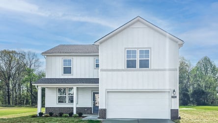 A white house with a garage with Rockingham Meeting House in the background.