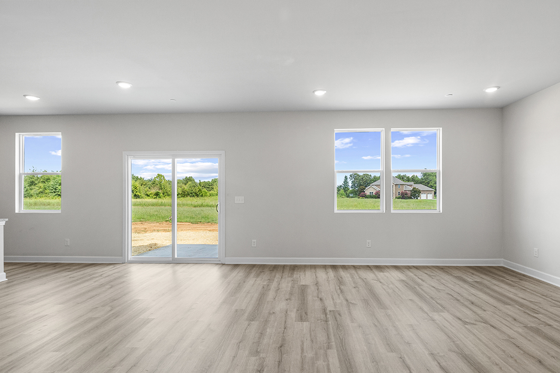 A room with windows and a wood floor.