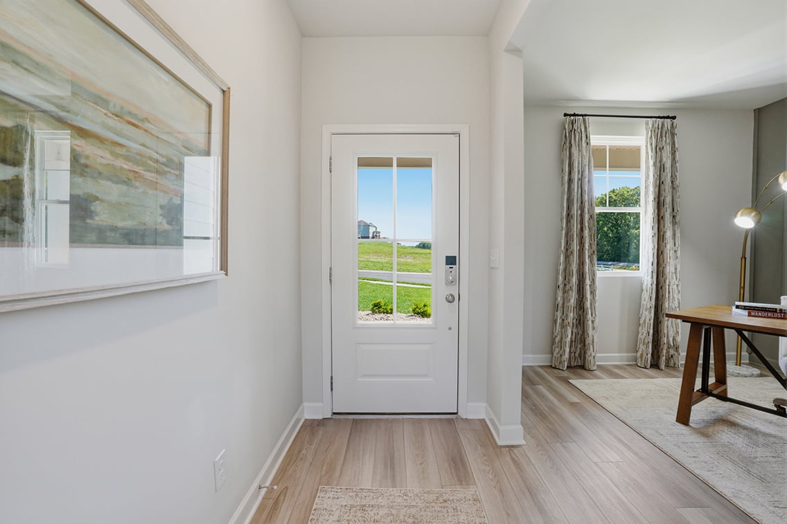A room with a door and a rug.