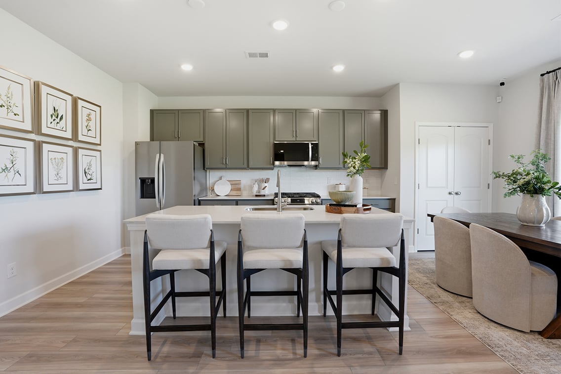 A kitchen with a dining table and chairs.