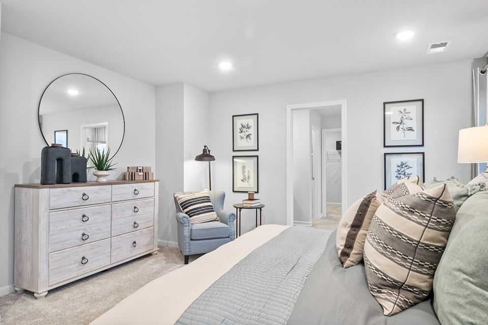 A bedroom with a bed and a chair.
