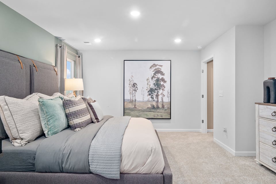 A bedroom with a large painting on the wall.
