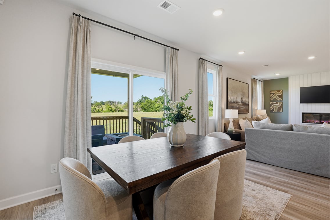 A dining room table with chairs and a large window.