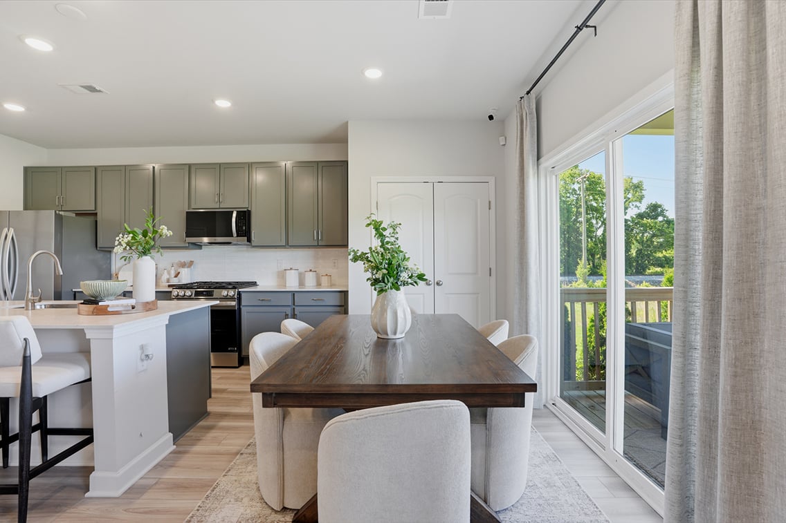 A kitchen with a table and chairs.