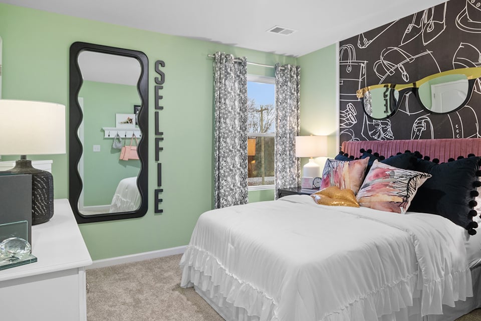 A bedroom with a large mirror.