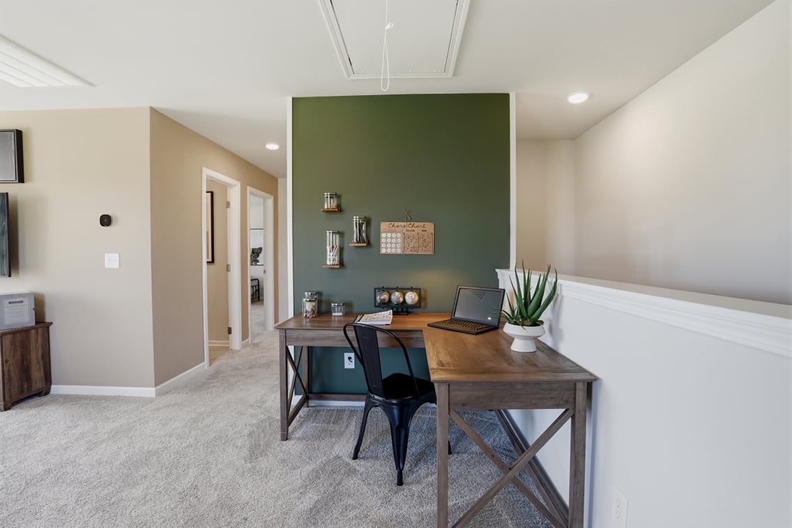 A room with a desk and a laptop on it.