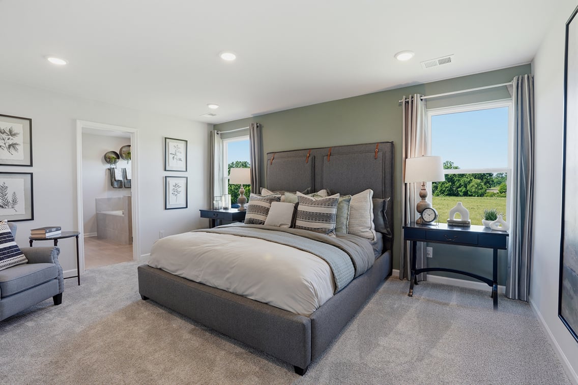 A bedroom with a bed and a lamp.