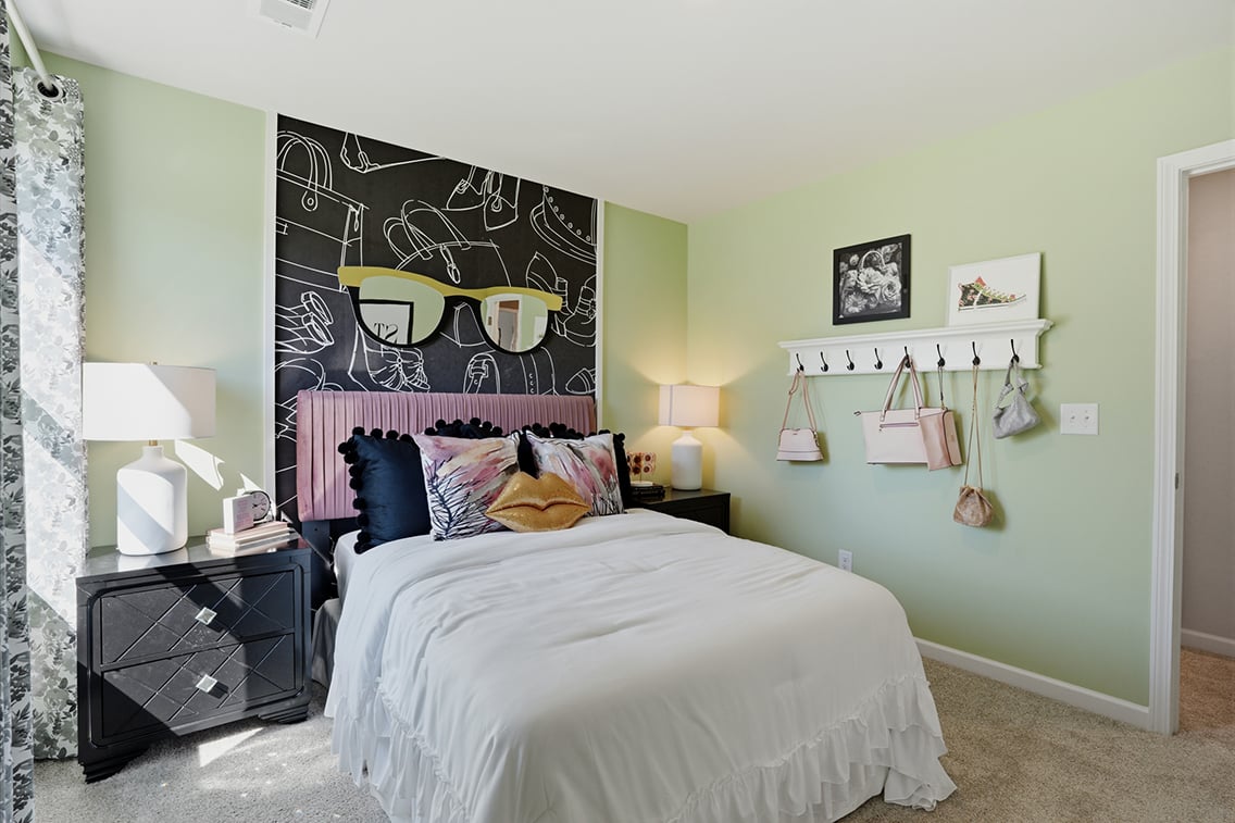 A bedroom with a bed and lamps.