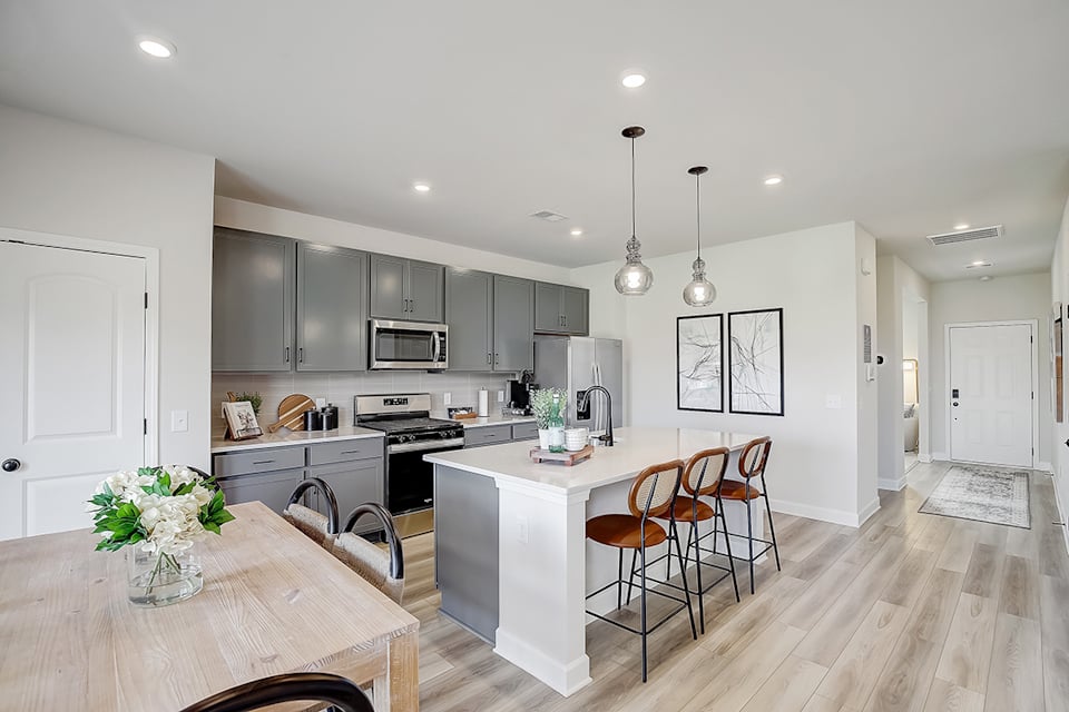 A kitchen with a dining table and white cabinets.