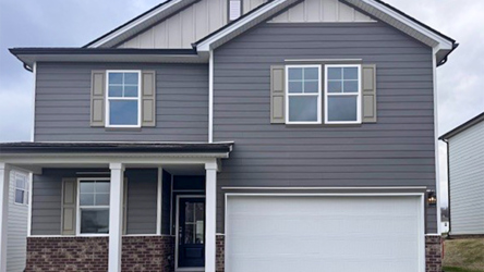 A grey house with garages.