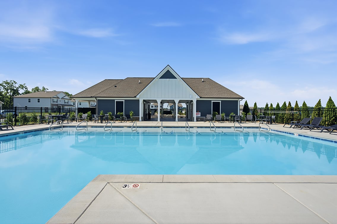 A swimming pool in front of a house.