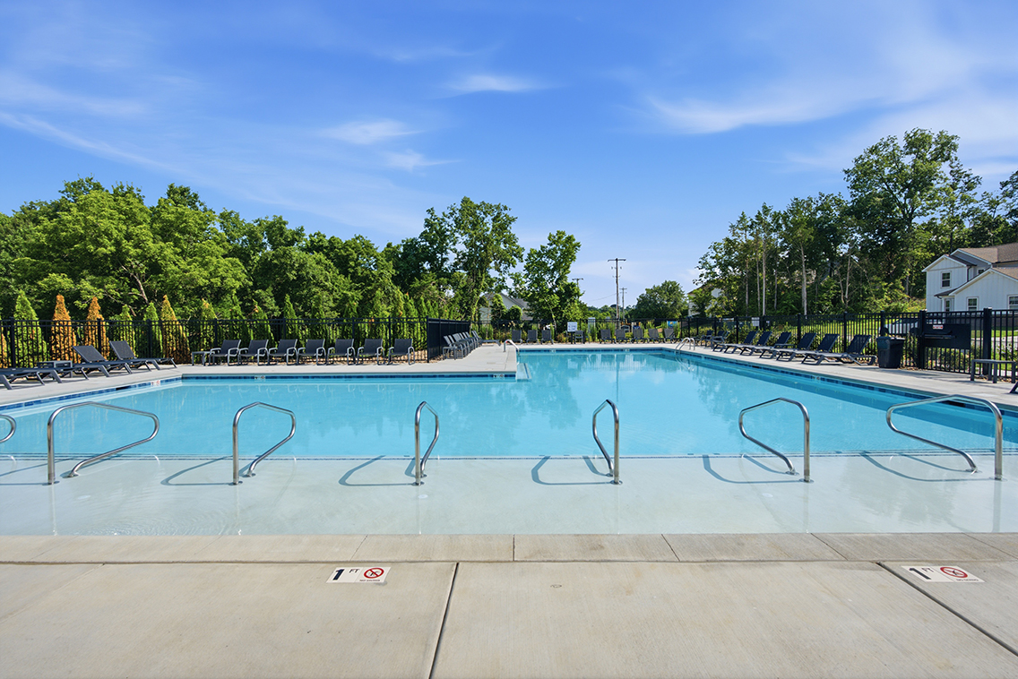 A swimming pool with trees in the background.