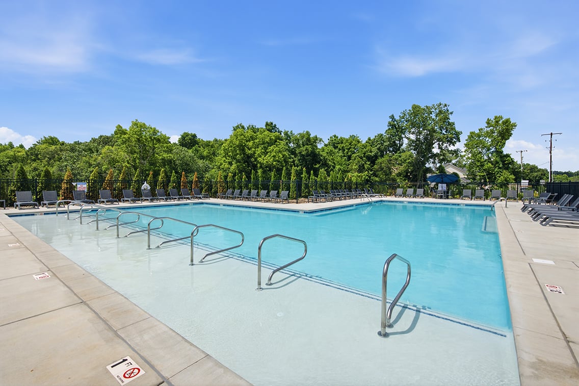 A swimming pool with trees in the background.