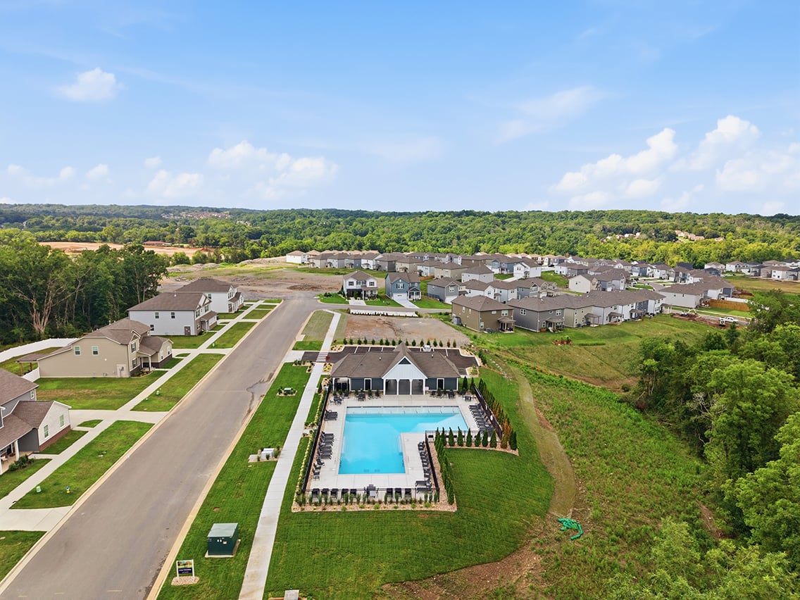 A swimming pool surrounded by trees and buildings.