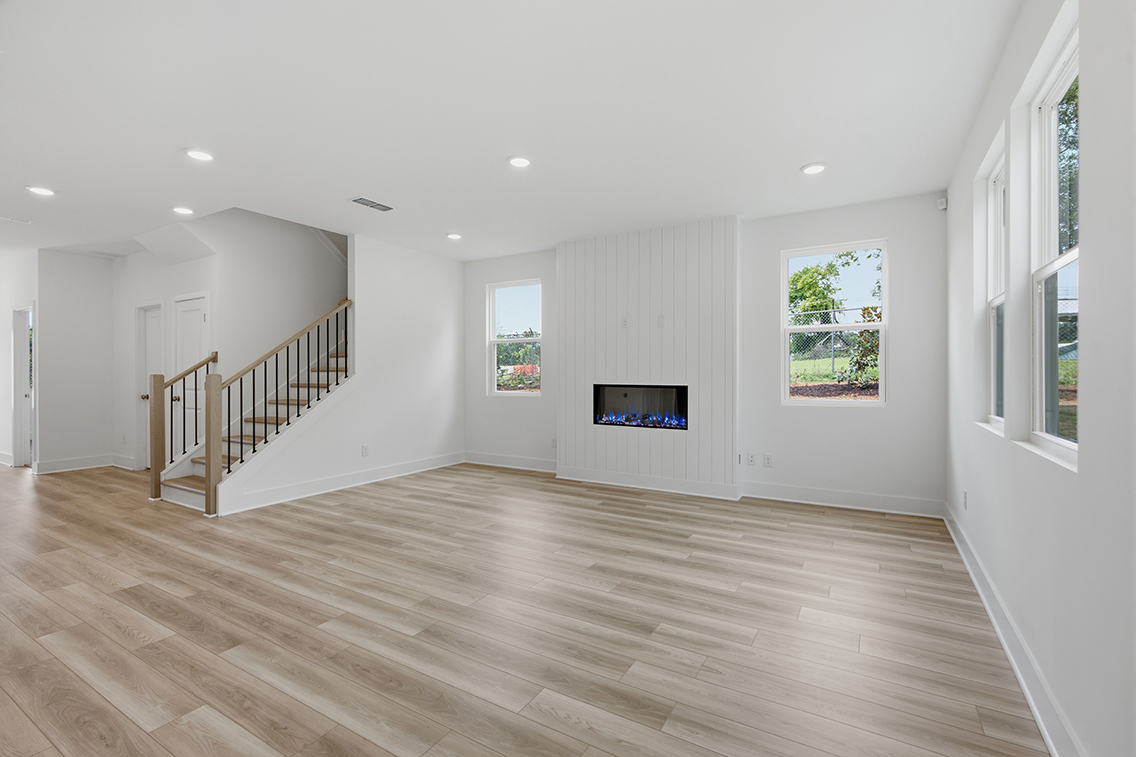 A large empty room with a wood floor and a wood floor.