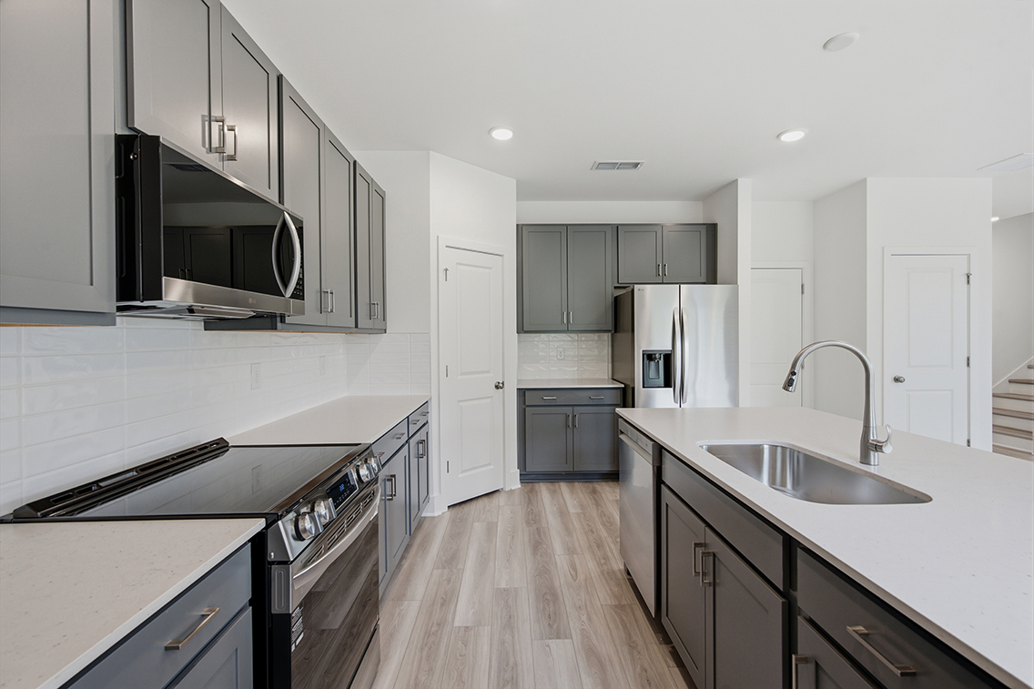 A kitchen with white cabinets.