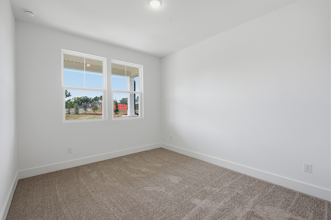 A room with a window and a carpet.