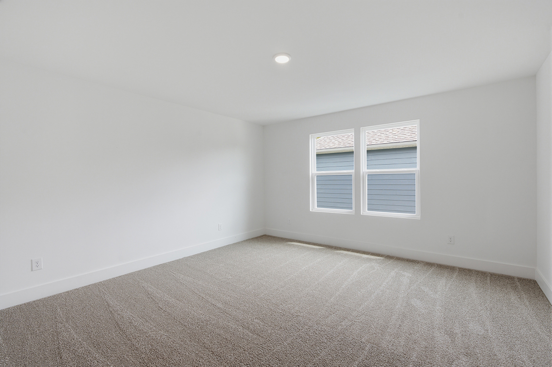 A room with a carpet and a window.