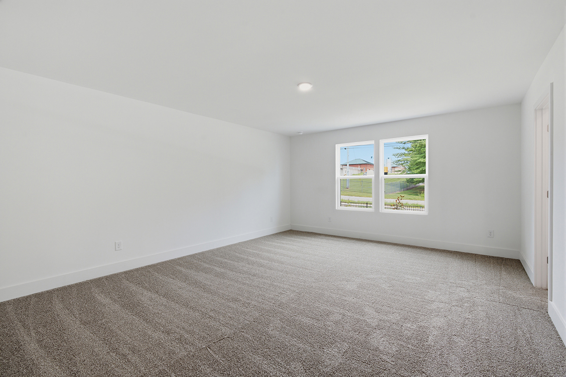 A room with a carpet and a window.