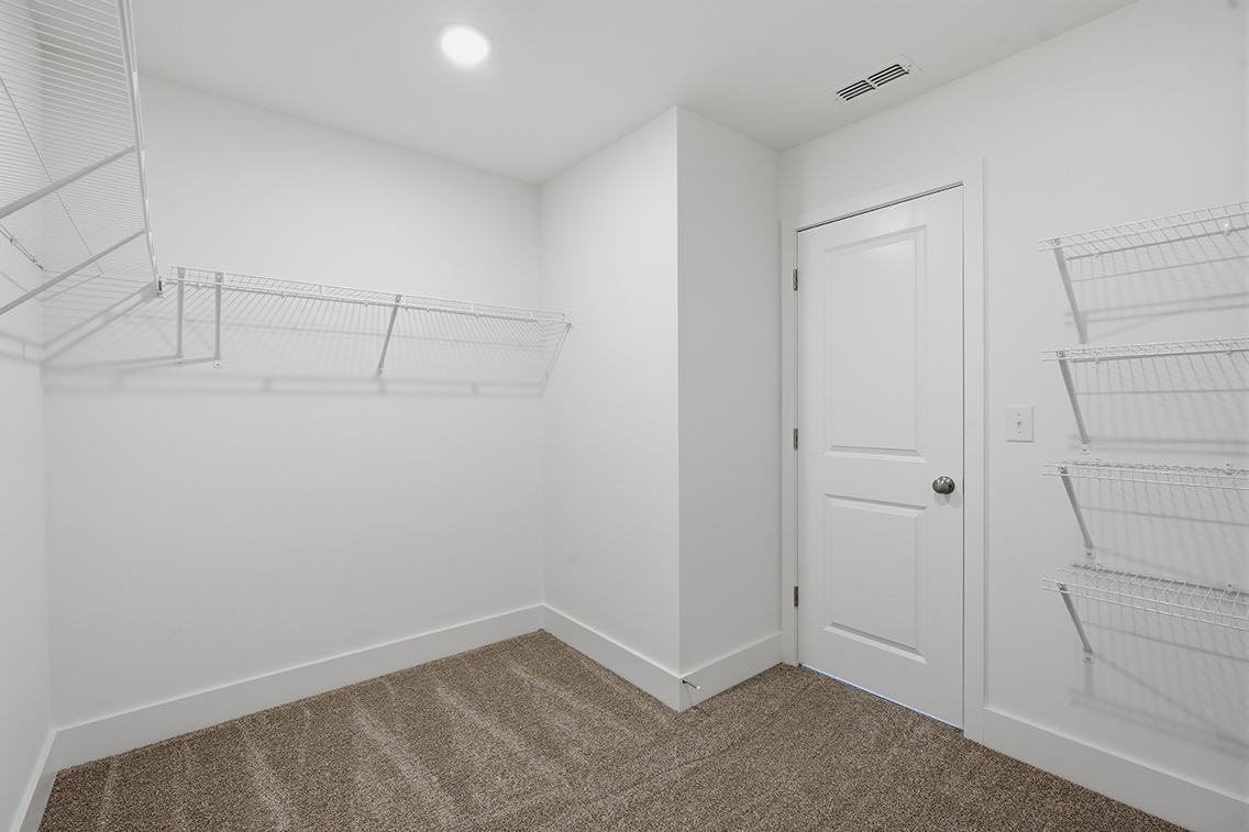 A white room with a white door and a white wall.