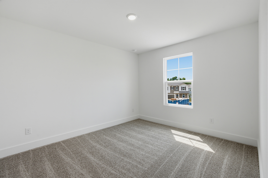 A room with a window and a carpet.