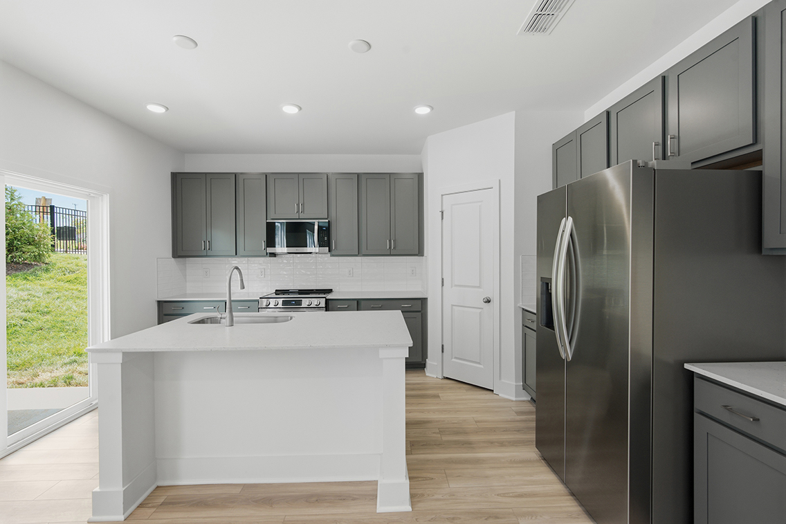 A kitchen with white cabinets.