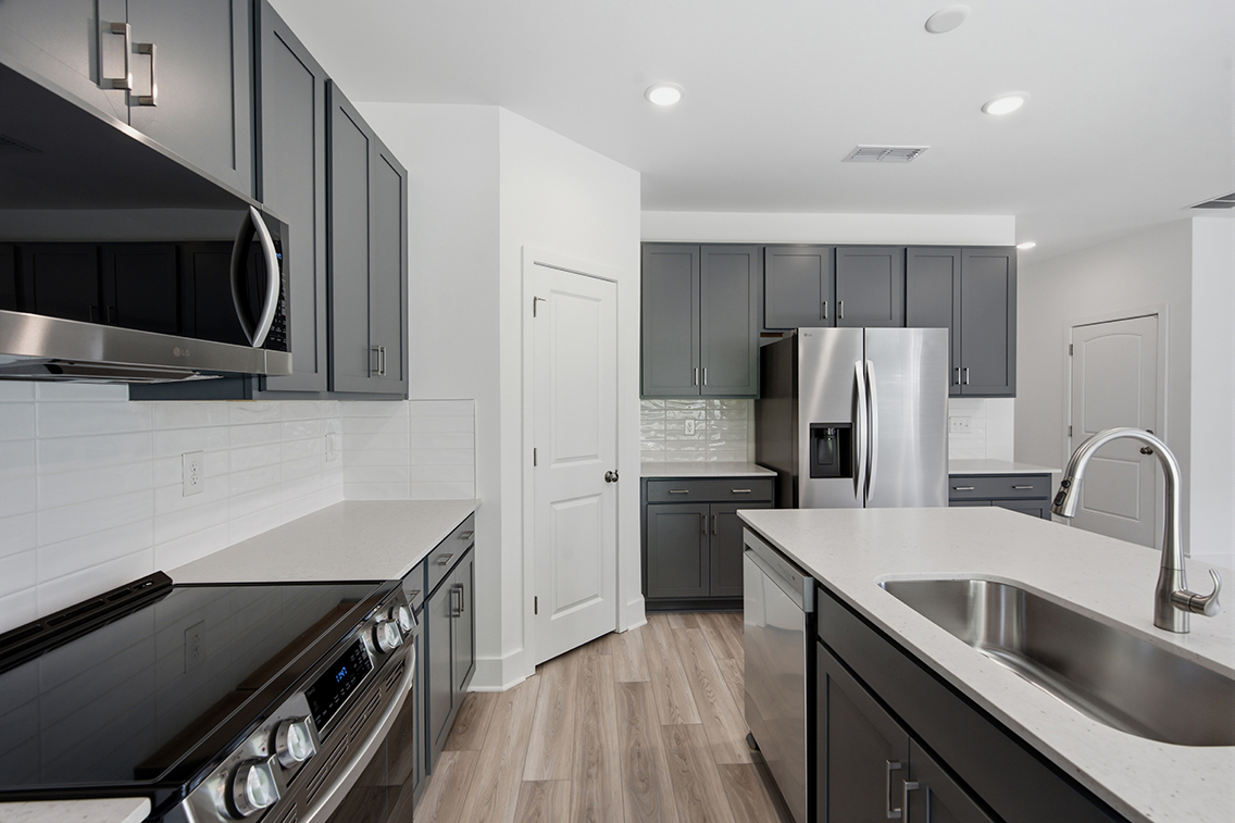 A kitchen with black cabinets.