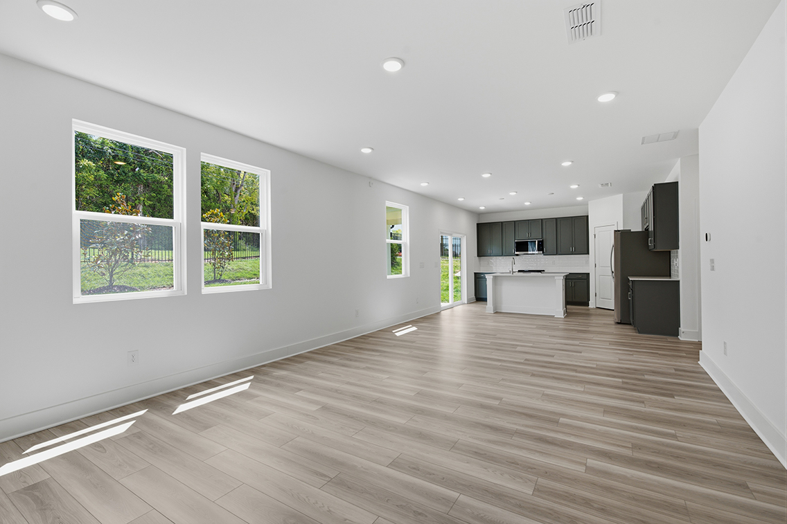 A large empty room with a wood floor and a wood floor.