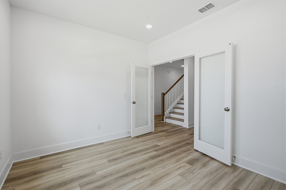 A room with white walls and a wood floor.