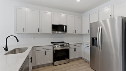 A kitchen with white cabinets.