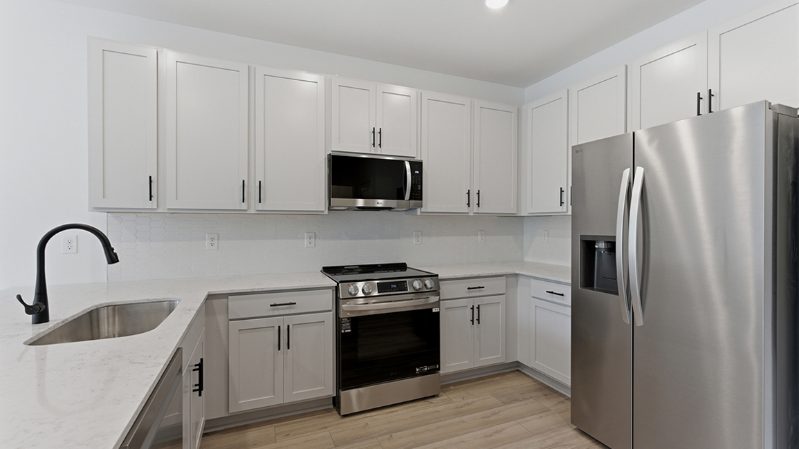 A kitchen with white cabinets.