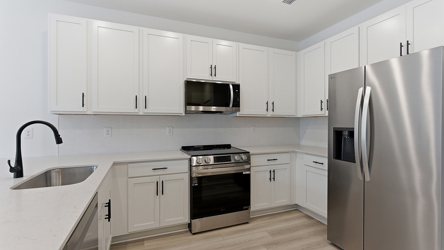 A kitchen with white cabinets.