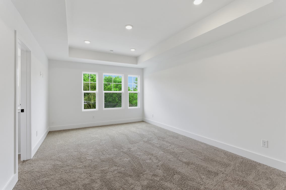 A room with a carpet and windows.