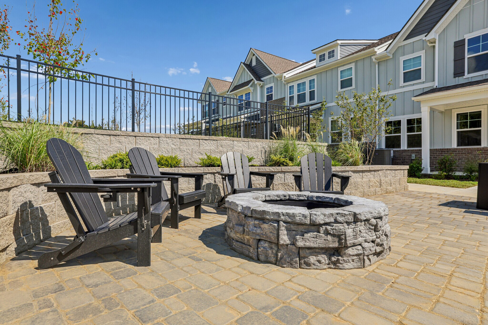 A patio with benches and a fire pit in front of a building.