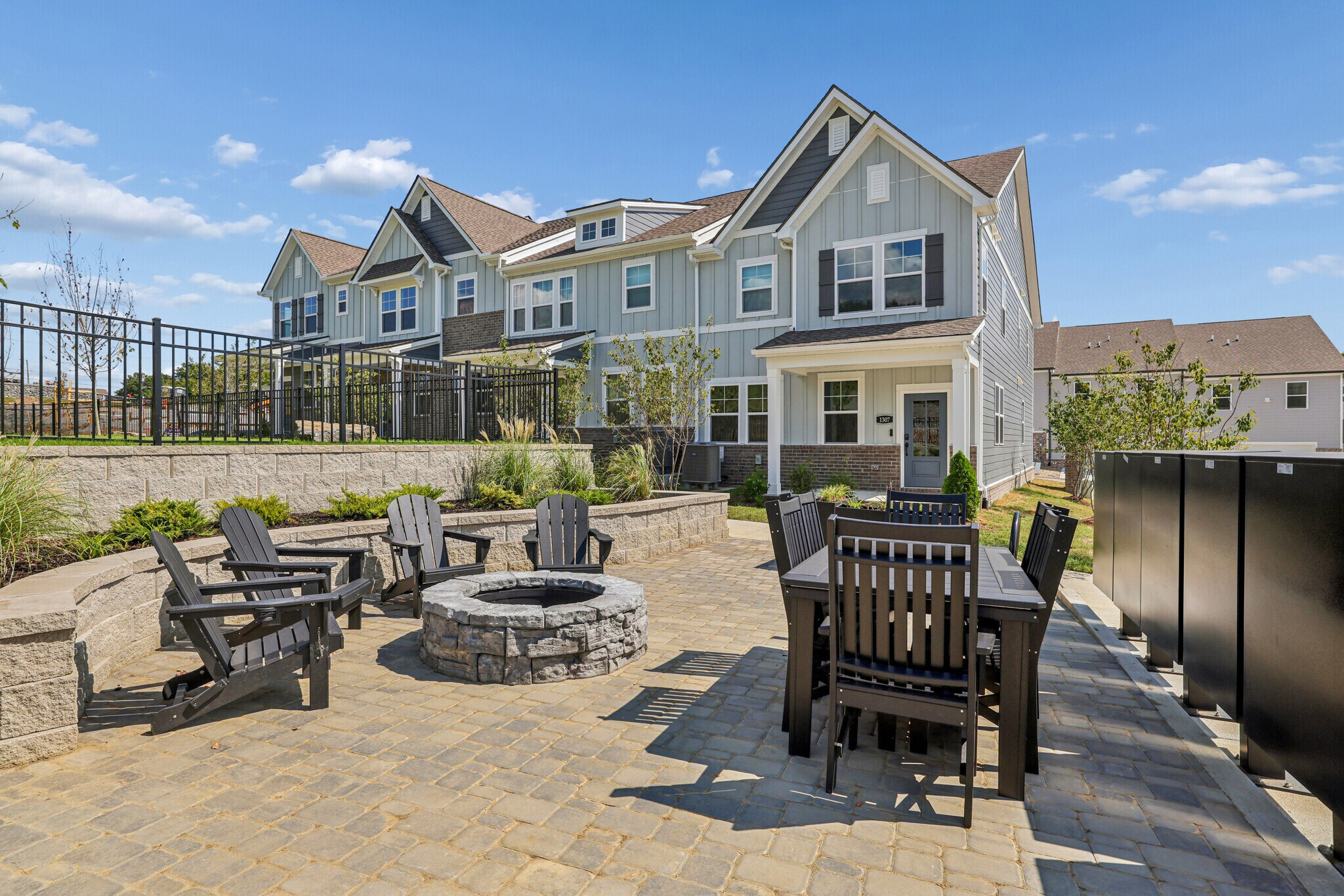 A patio with tables and chairs in front of a house.